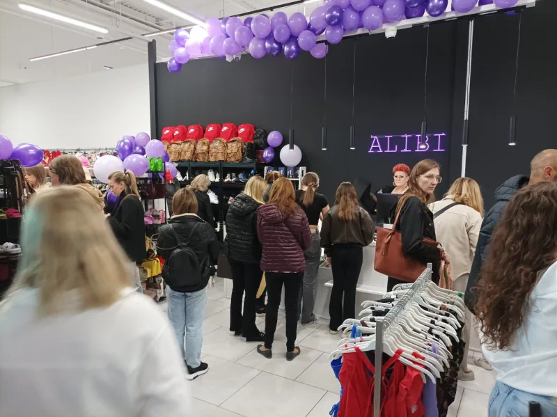 Wnętrze Alibi Outlet w E.Leclerc z osobami przy ekspozycji odzieży